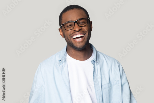 African man with white smile pose isolated on gray background © fizkes