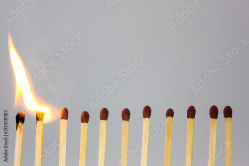 line of matches igniting in a chain reaction photo