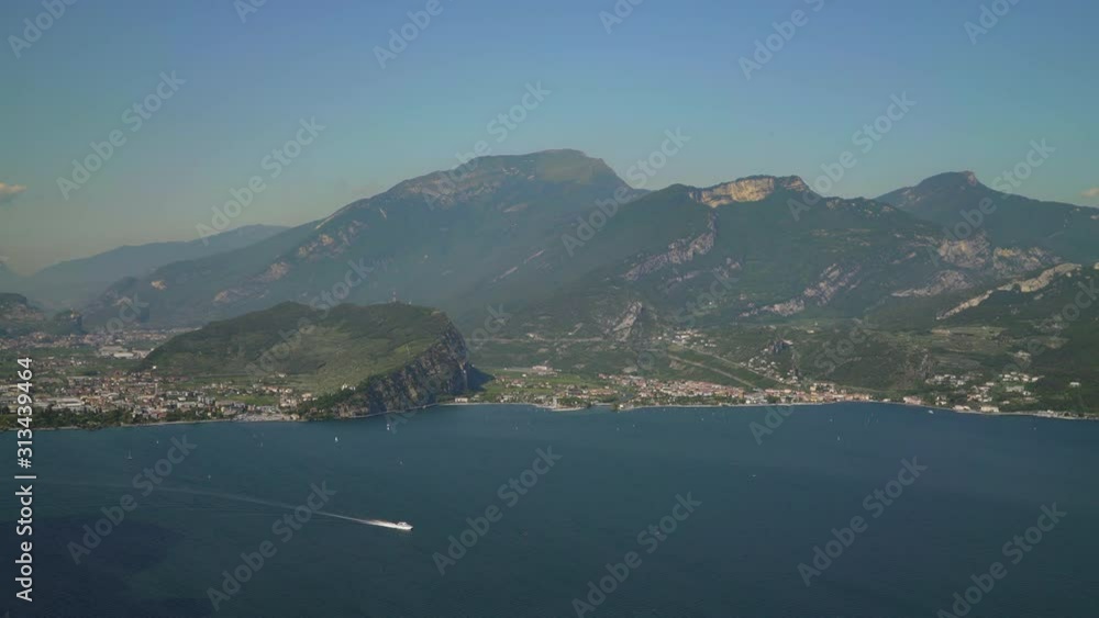 Left to right pan real time wide shot of lake Garda and mountains. Lake Garda is the largest lake in Italy. Left to right pan real time wide shot of lake Garda and mountains. Lake Garda is the largest lake in Italy.