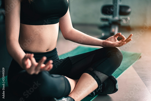 fitness ,workout, gym exercise ,lifestyle and healthy concept. Women practice yoga sitting posture, meditation, stretching at the indoor gym for good health at sunset. Side view image
