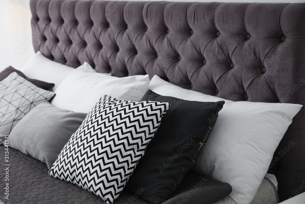 Soft pillows on modern bed in room - obrazy, fototapety, plakaty 