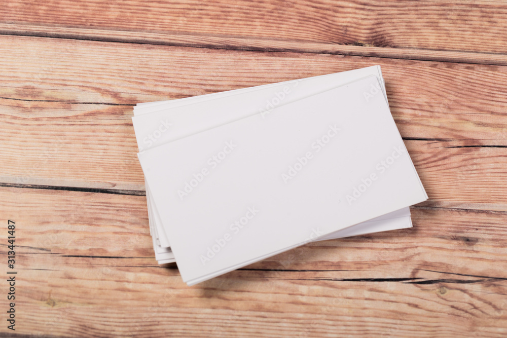 Photo of empty business cards on a light natural wooden background .. Template for identifier. Photo of empty business cards on a light natural wooden background .. Template for identifier.