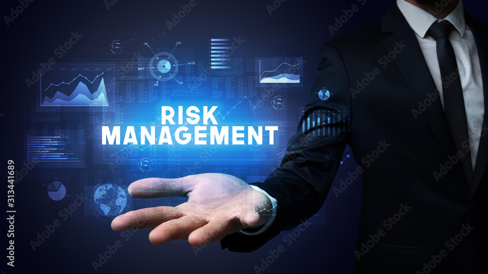 Hand of Businessman holding RISK MANAGEMENT inscription, business success concept Hand of Businessman holding RISK MANAGEMENT inscription, business success concept