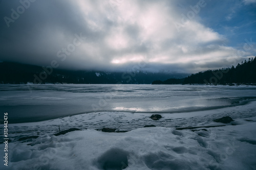 Gefrorener See mit Steinen und Wald