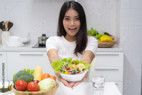 Fresh organic foods. Girl holding salad on bowl.