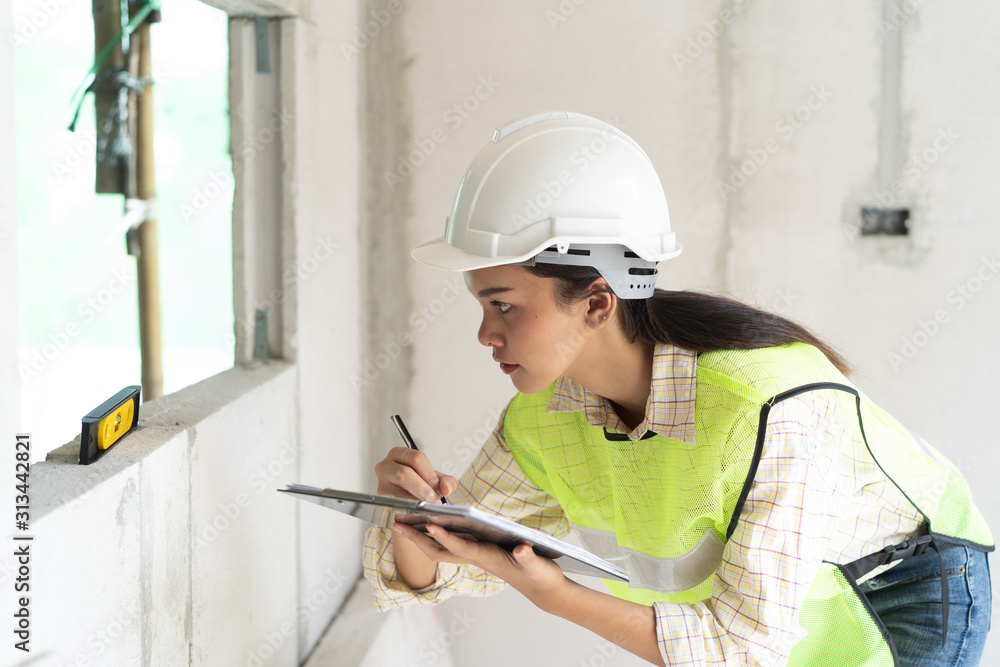 Fototapeta premium Female worker occupation. Woman inspector / architect checking interior material process in house reconstruction project.
