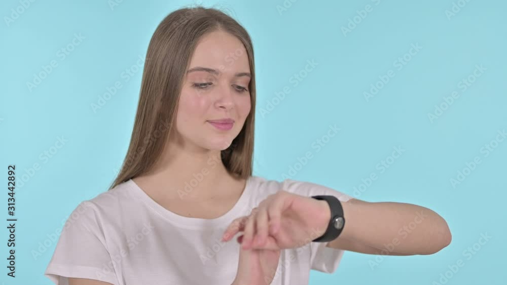 Beautiful Young Woman Using Smartwatch, Blue Background Beautiful Young Woman Using Smartwatch, Blue Background