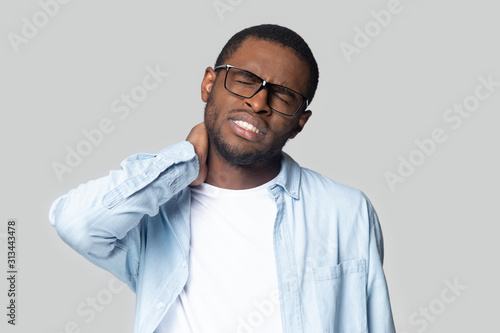 Bilde på lerret African unhealthy guy suffers from stiff neck studio shot