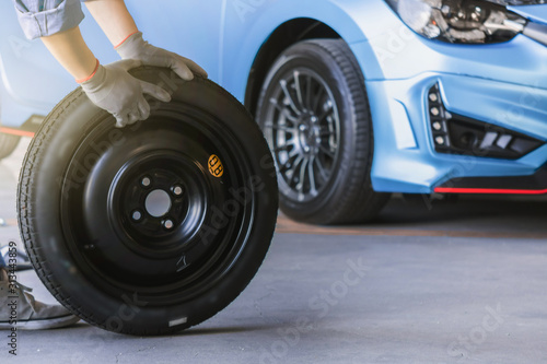 Asian man car inspection Measure quantity Inflated Rubber tires car.Closeup hand holding tire and blue car for tyre pressure measurement for automotive, automobile Car industry image © OATZ TO GO FACTORY