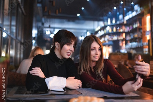 two pretty women making selfie sitting At the restaurant table © Galina_lya