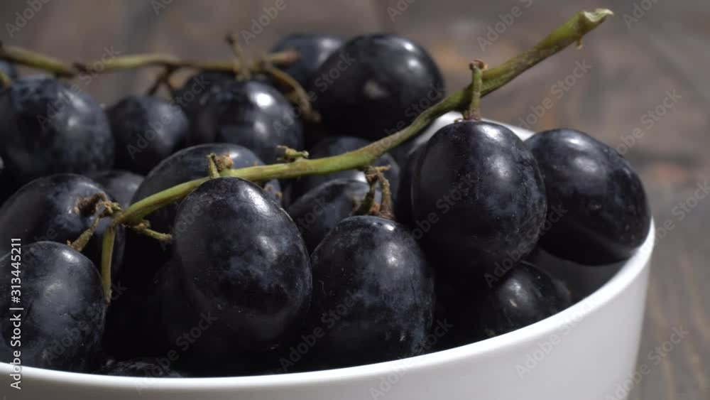 Uvas negras en un bol en la mesa, detalle Uvas negras en un bol en la mesa, detalle