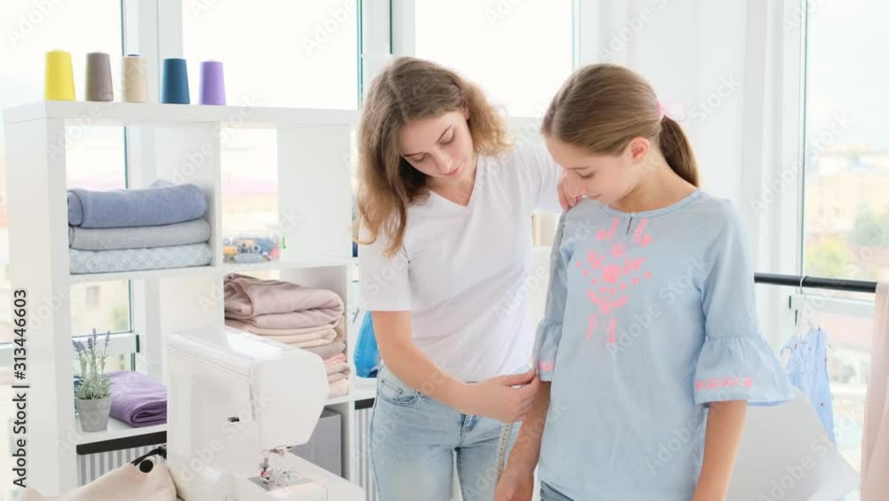 Designer taking measurements of her client Designer taking measurements of her client