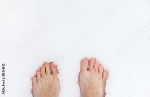Barefoot man standing on snow