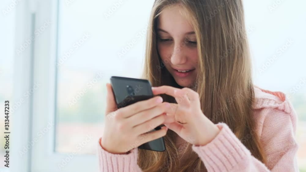 Beautiful teenage girl looking into mobile phone Beautiful teenage girl looking into mobile phone