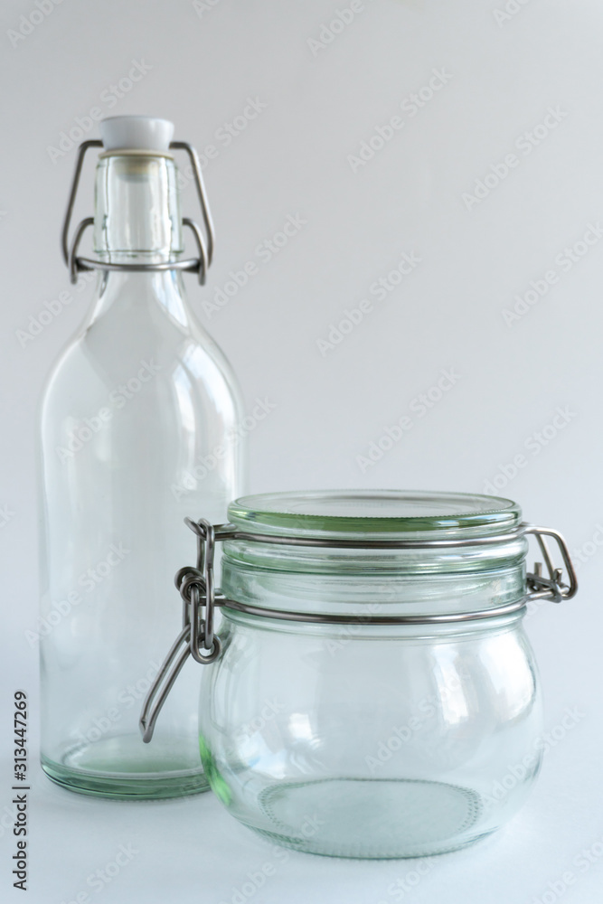 Glass jar and bottle at white backdrop. Zero waste concept. Glass jar and bottle at white backdrop. Zero waste concept.