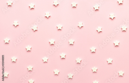 White sweet star lollipops on a pink background macro view
