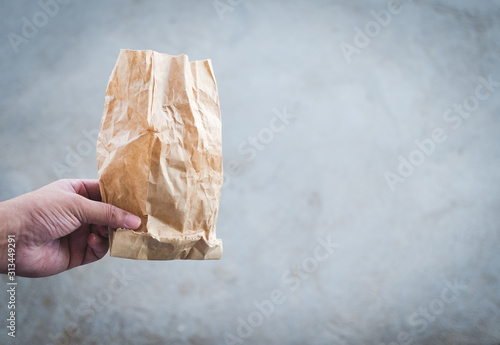 man hand holds used paper bag
