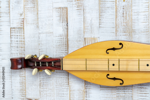 Appalachian mountain dulcimer musical instrument on a rustic white wooden background photo