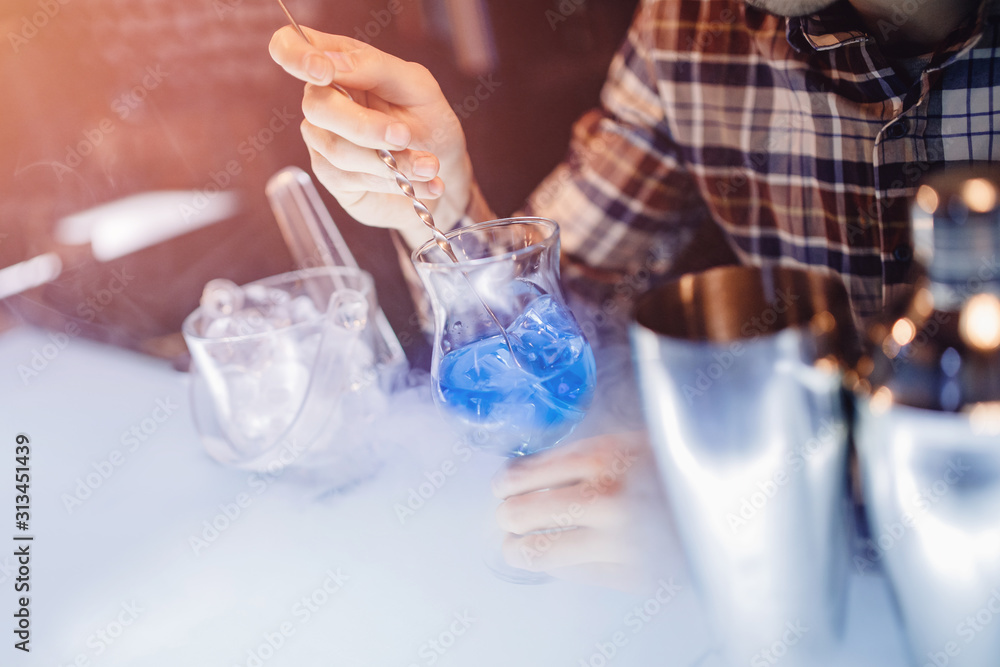 Barman mixes blue cocktail show with colorful alcoholic and smoke bar counter Barman mixes blue cocktail show with colorful alcoholic and smoke bar counter