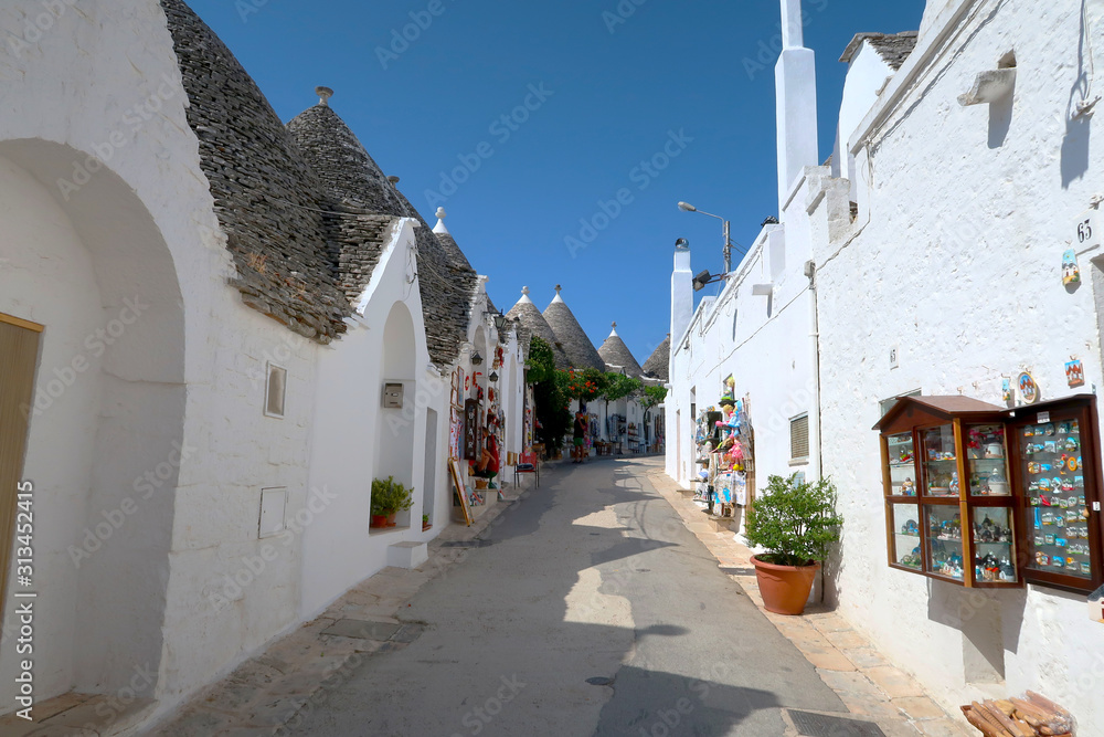 The traditional Trulli houses in the street of Alberobello city, Italy, Apulia region, Adriatic Sea with typical souvenir shops