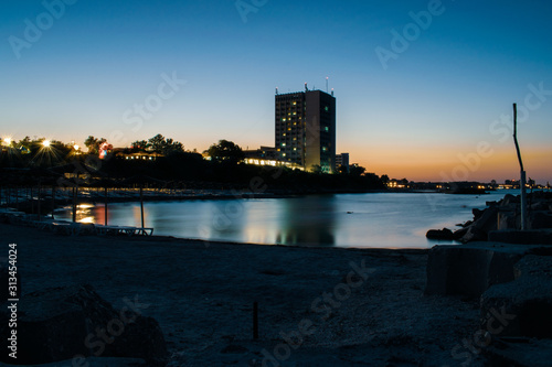 A nice night view of the Black Sea with a colorful sky and buildings in the back