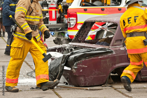 Demonstration of rescue work. Firefighters break into a car after an accident. Rescue team retrieve the victim from the burned car. Training firefighters.