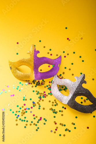 A festive, colorful group of mardi gras or carnivale mask on a yellow purple background. Venetian masks. photo