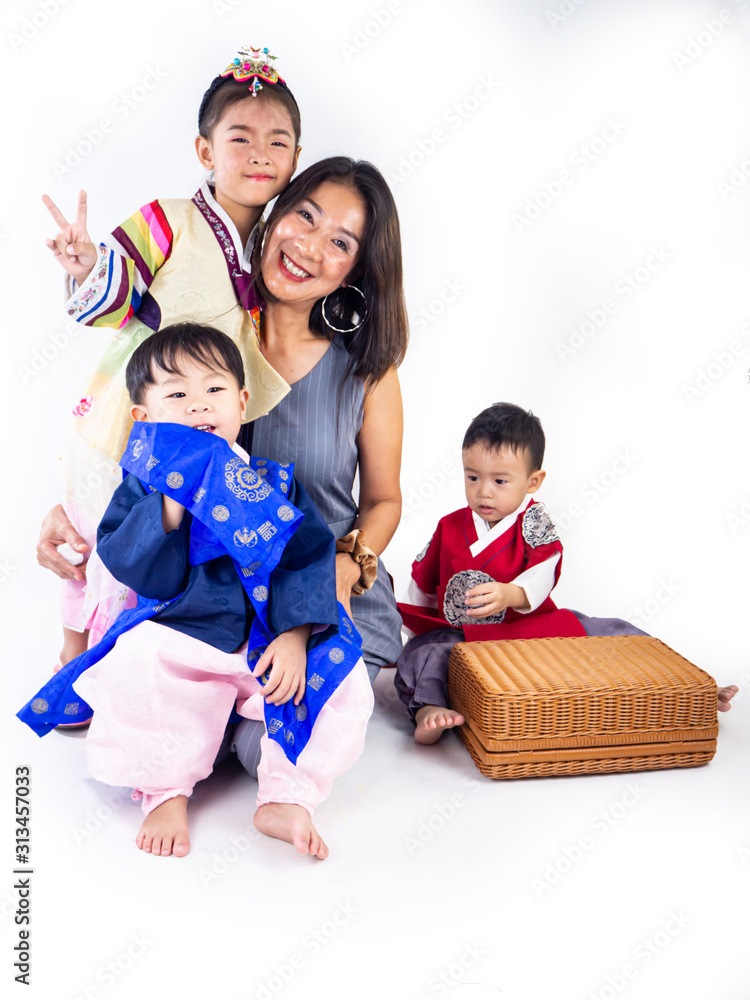 Fototapeta premium Asian little boy and girl wearing a Korean Traditional Hanbok dress in Rattan bag on white background