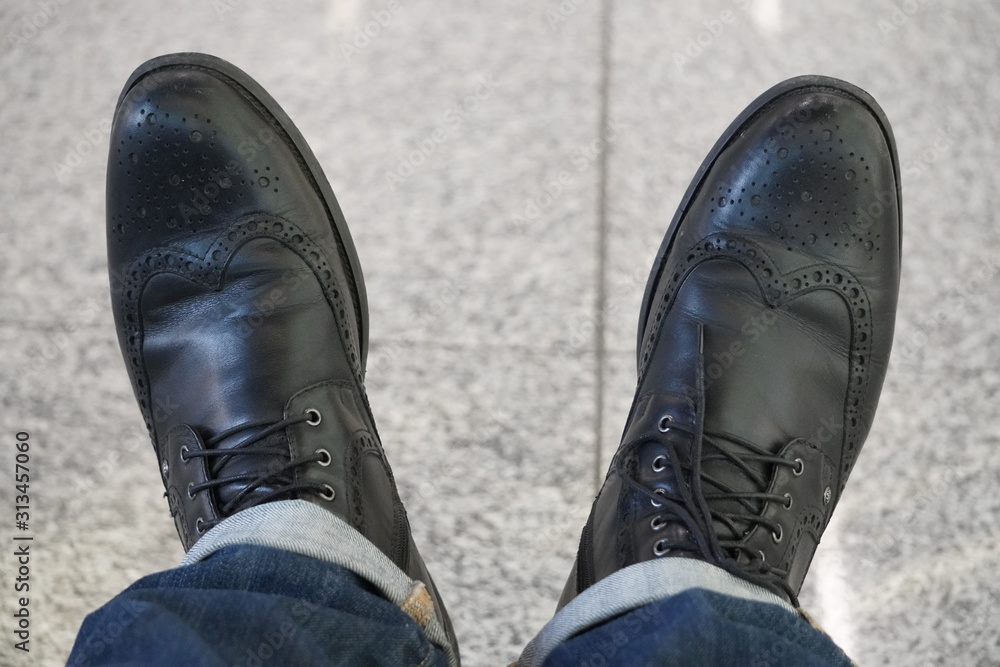 black men's autumn boots with laces and brogues, black shoes with jeans.  Against the background of light gray tile floor. loneliness, alone Stock  Photo | Adobe Stock