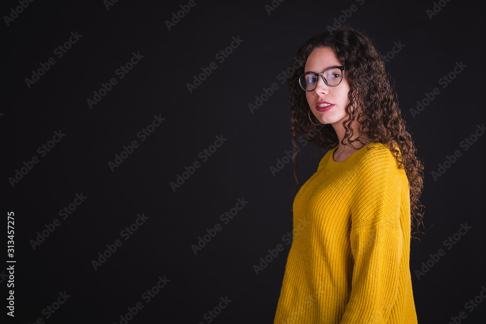 Young girl model posing with yellow t-shirt and blue pants in black background Young girl model posing with yellow t-shirt and blue pants in black background