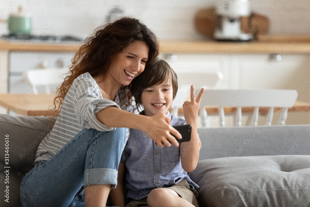 Cheerful mother holding smartphone making selfie with son Cheerful mother holding smartphone making selfie with son