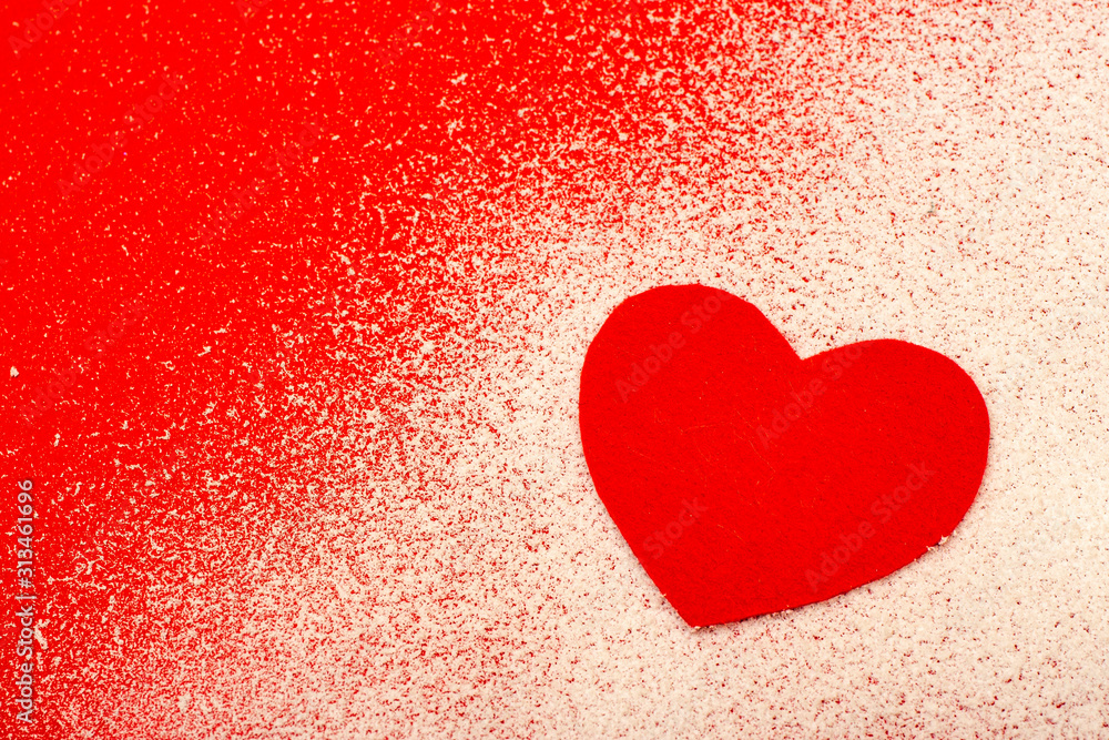 Red heart on white snow is a symbol of hot love.