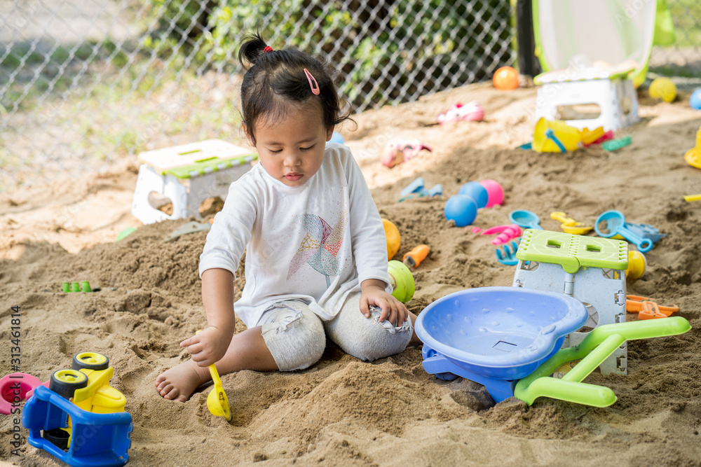 Cute little girl playing with sand at playground. Cute little girl playing with sand at playground.