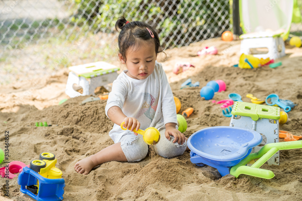 Cute little girl playing with sand at playground. Cute little girl playing with sand at playground.