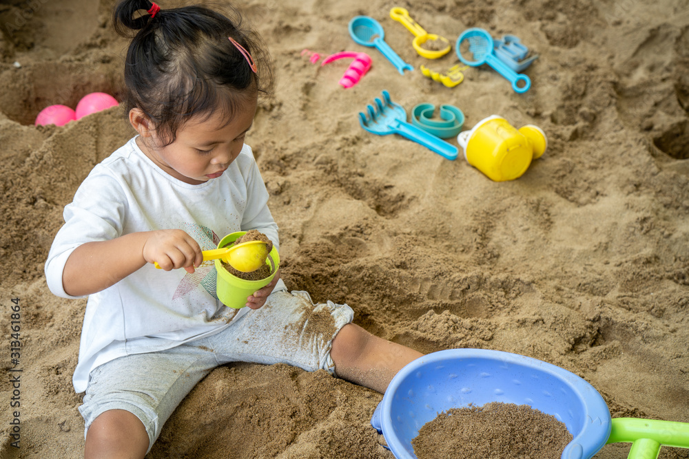 Cute little girl playing with sand at playground. Cute little girl playing with sand at playground.
