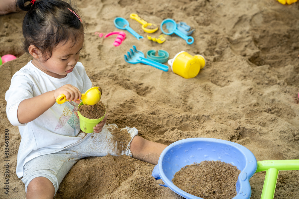 Cute little girl playing with sand at playground. Cute little girl playing with sand at playground.