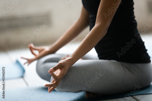 Close up African American woman doing Padmasana exercise, practicing yoga