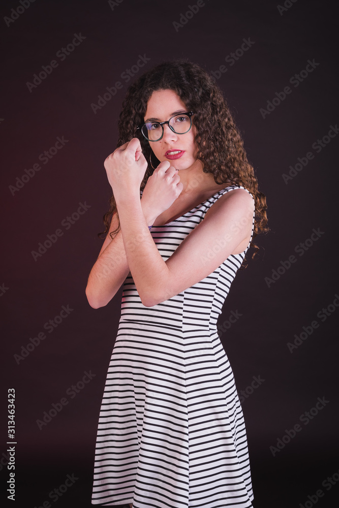 Young girl model posing with cute dress in black background Young girl model posing with cute dress in black background