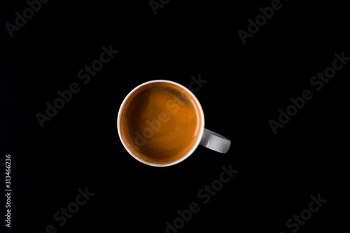 Cup of coffee over the black background