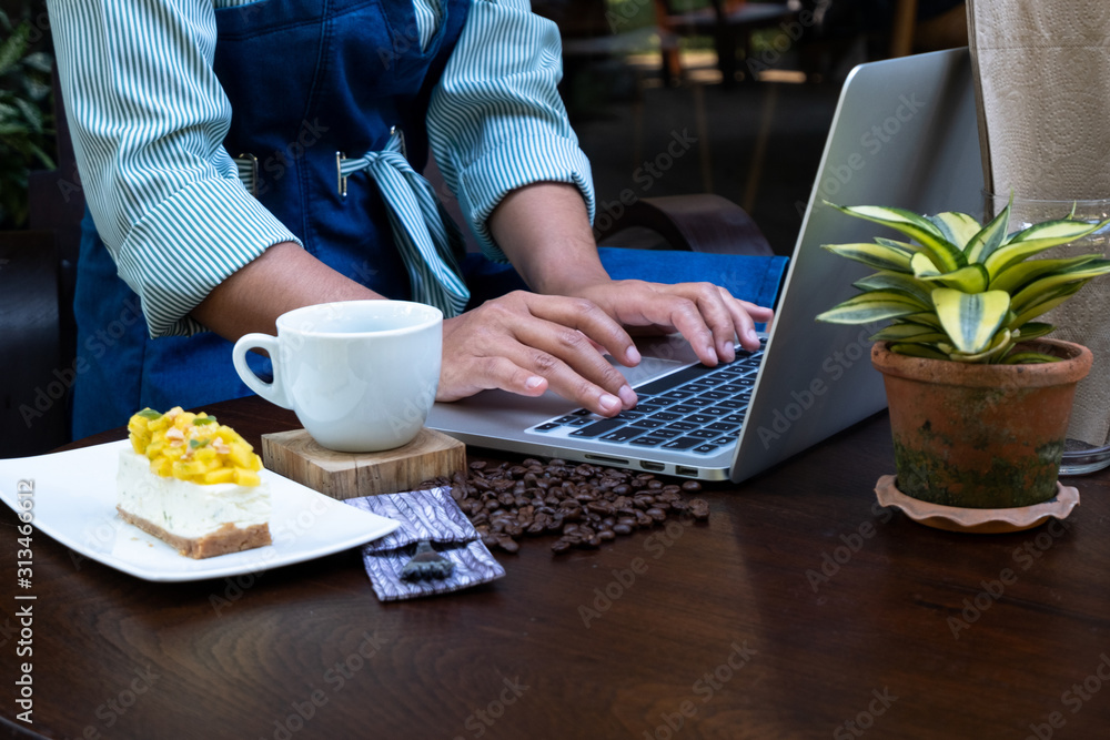 A woman using laptop to work and drink coffee in a coffee shop A woman using laptop to work and drink coffee in a coffee shop