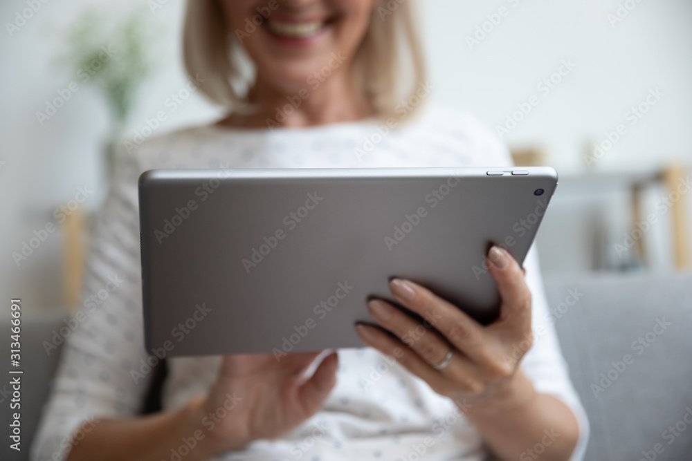 Close up of mature woman using modern tablet gadget Close up of mature woman using modern tablet gadget