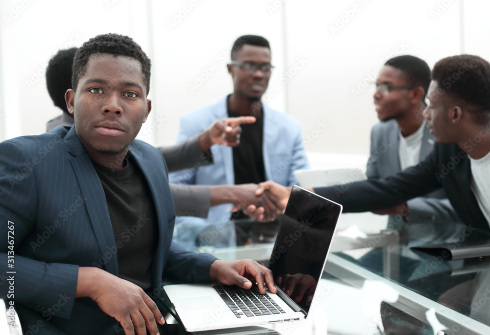 young businessman uses laptop sitting at office Desk. young businessman uses laptop sitting at office Desk.