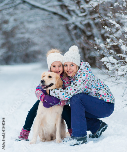 Family playing with his pet on Christmas holidays in frozen forest