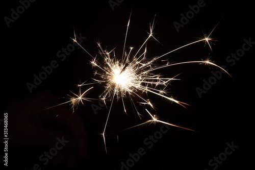 Sparkler with light and fire in hand of child during new years eve