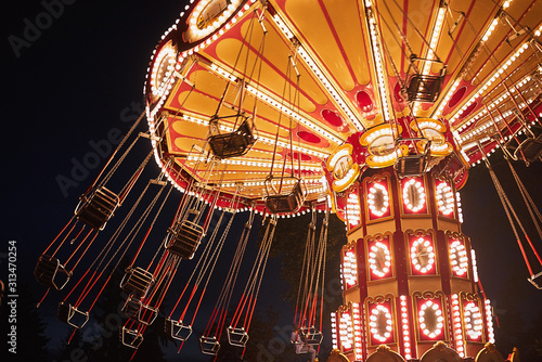 Photographie Illuminated swing chain carousel in amusement park at the night