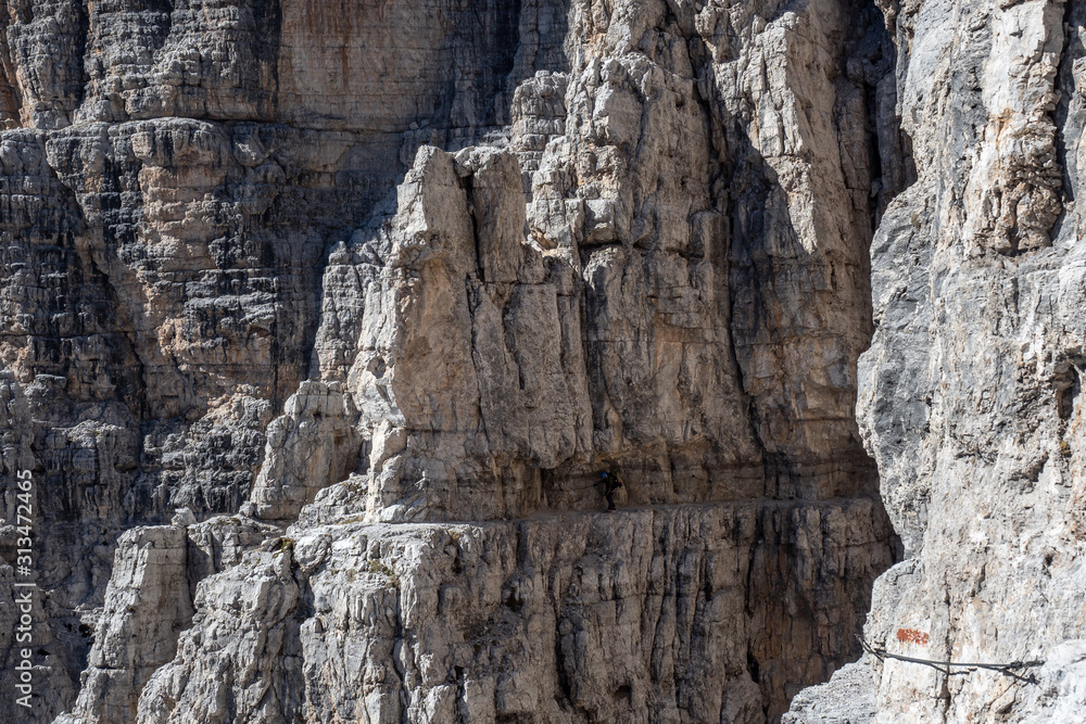 Male mountain climber on a Via Ferrata in breathtaking landscape of Dolomites Mountains in Italy. Travel adventure concept. Male mountain climber on a Via Ferrata in breathtaking landscape of Dolomites Mountains in Italy. Travel adventure concept.