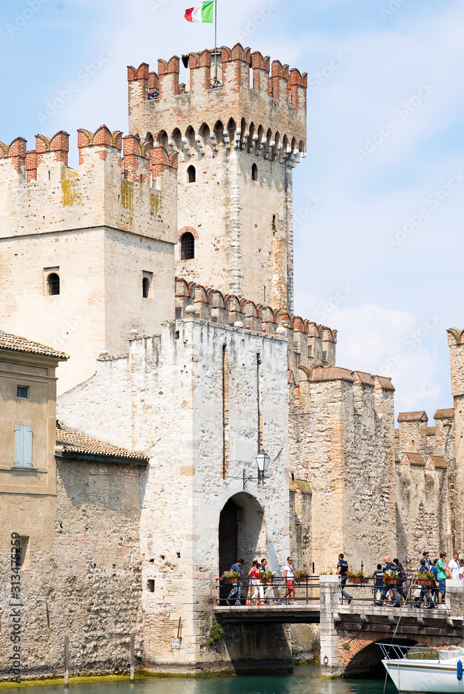 Fortress walls of the Scaligero Castle or Castle of Sirmione surrounded by water canals of the Garda lake.