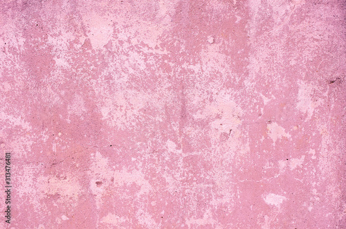 Fragment of old house wall close-up. Pink background. Peeling plaster on concrete surface. Cracks in paint. Copy space. Place for text. Selective focus image.