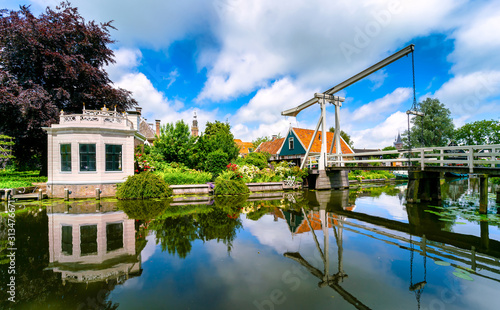 Kwakel draw bridge in the historic town Edam, Netherlands. Kwakel draw bridge is an old bridge with counter-balance construction. Calm view of the canal, waterfront houses and church tower