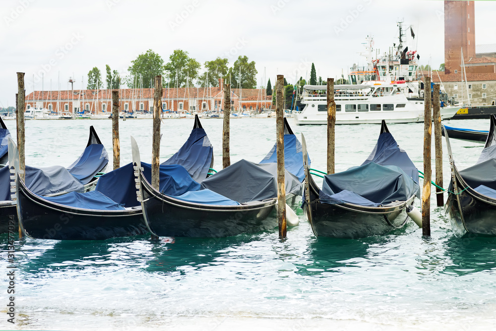 Gondolas moored by Saint Mark square with San Giorgio di Maggiore church in Venice, Italy,